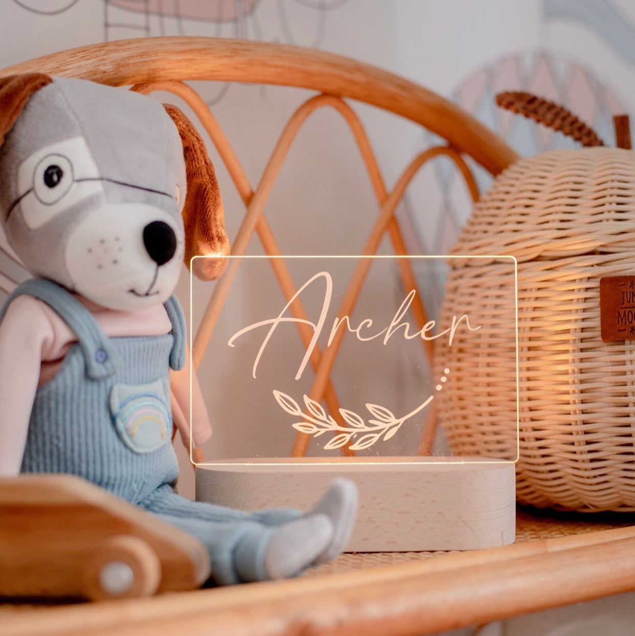 Stuffed animal toy with a lamp labeled 'Archer' on a wooden surface.